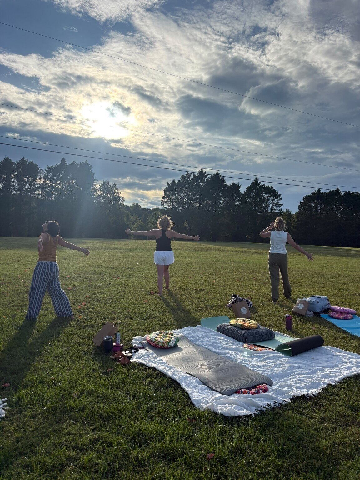 Guests opening their arms toward the sky during an outdoor RETURN gathering