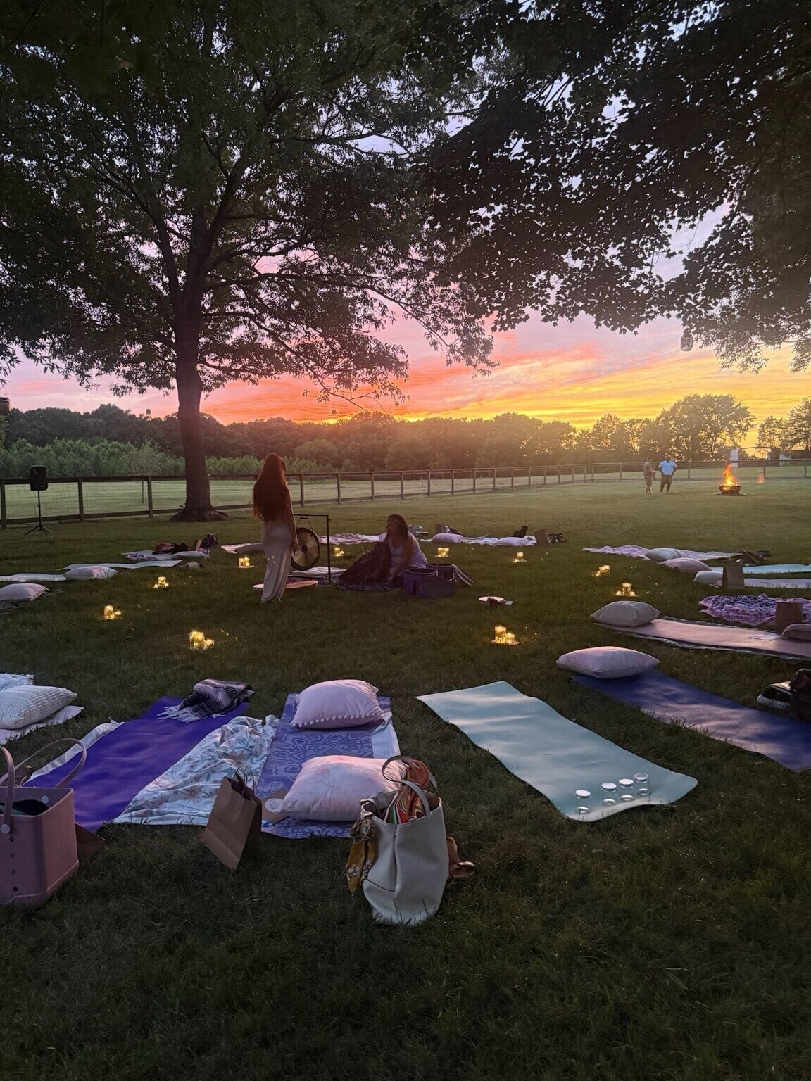 A candlelit Summer Solstice gathering prepared beneath a glowing sunset