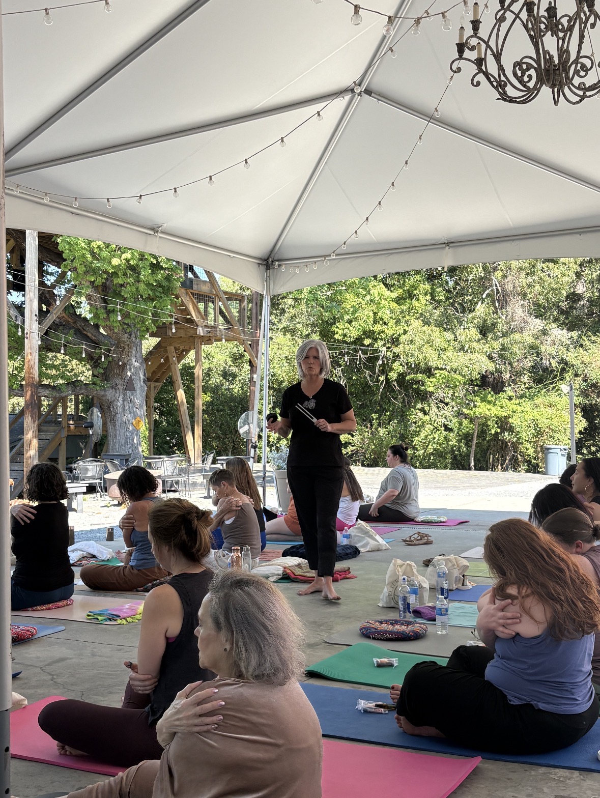 RETURN guests sharing a guided self-embrace practice beneath the pavilion