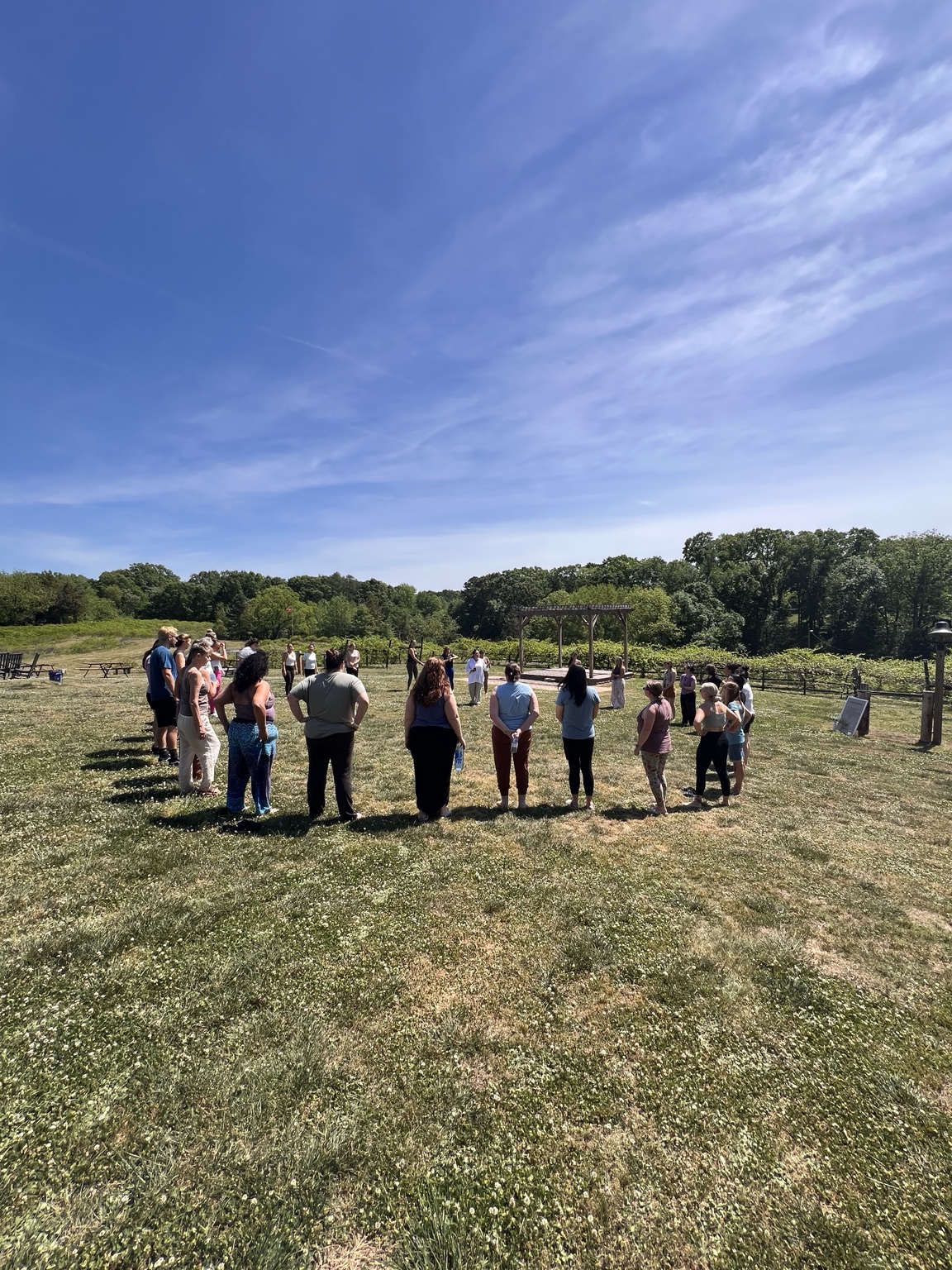 A large community circle gathered outdoors during the Earth Day RETURN experience